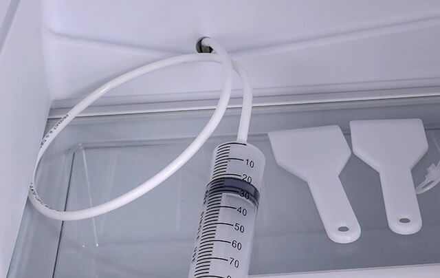 чистка дренажной системы холодильника Liebherr с помощью шприца и шланга